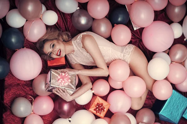 Retro vrouw in ballonnen met de gift van de verjaardag. — Stockfoto