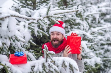 Noel mutlu adam tutun mevcut kutusu karlı kış ormanda