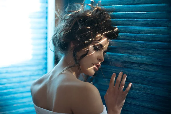 Mujer sensual con maquillaje en la ventana. Belleza y look de moda. Mujer de moda con maquillaje y cabello rizado. chica elegante con el pelo de moda. Hermosa mujer. Elegante y seguro — Foto de Stock