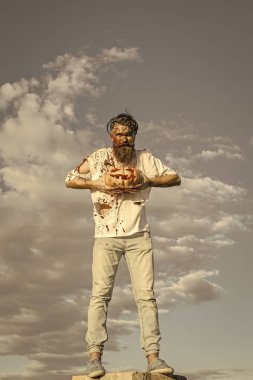 Cadılar Bayramı hipster üzerinde gri gökyüzü yüksek ayakta kabak ile