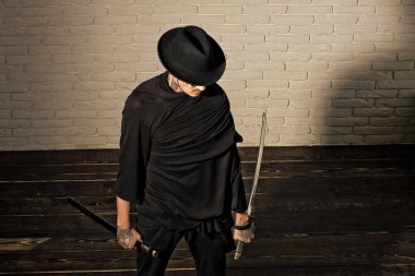 Adam ahşap zemin üzerinde duran kılıç