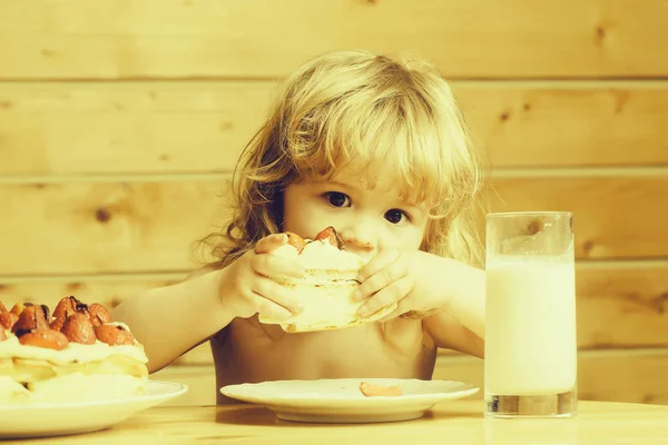 Kleine jongen met aardbeientaart en yoghurt — Stockfoto