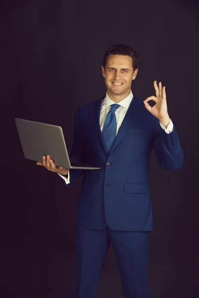El hombre que trabaja en el ordenador portátil y haciendo buen gesto — Foto de Stock