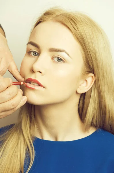 Visagiste masculino aplicando lápiz rojo en los labios de la chica —  Fotos de Stock