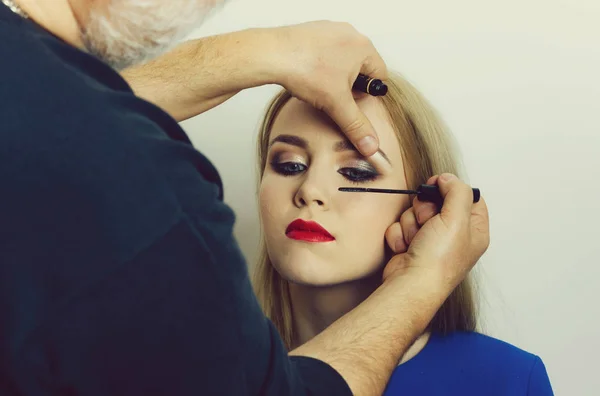 Visagiste applying black mascara on woman eyelashes — Stock Photo, Image