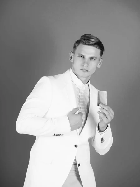 Бізнесмен позує в білій куртці, сорочці і штанях — стокове фото
