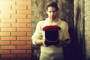 sakallı adam kutusunda mevcut olarak kırmızı gül çiçekler tutar