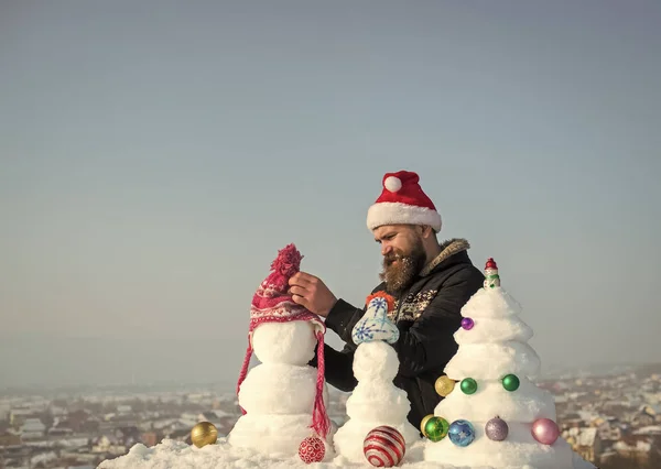 Santa man hoed zetten sneeuwpop — Stockfoto