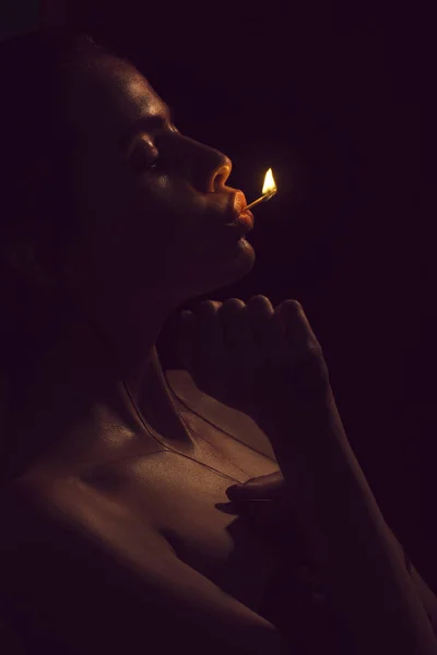Lány gazdaság égő gyufa a szájban — Stock Fotó
