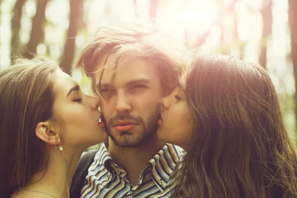 Девушки целуются бородатый мужчина — стоковое фото