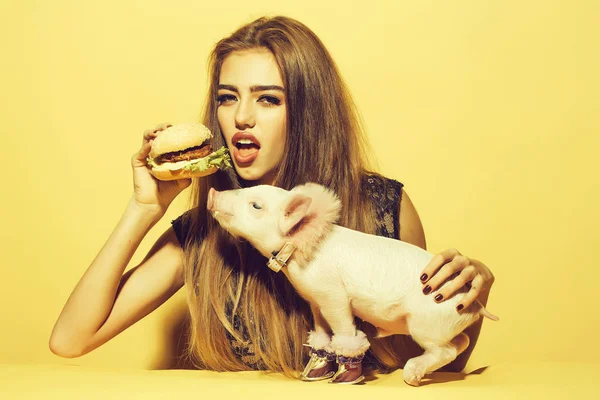 돼지와 함께 햄버거를 먹는 여자 — 스톡 사진