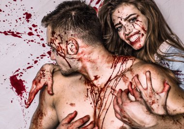 Cadılar Bayramı 'nda yakışıklı bir çift ve uzun saçlı seksi bir kız ve geleneksel sonbahar bayramı sembolü olarak kırmızı kan. Seksi kadın vampir bir erkeğin boynunu ısırıyor..