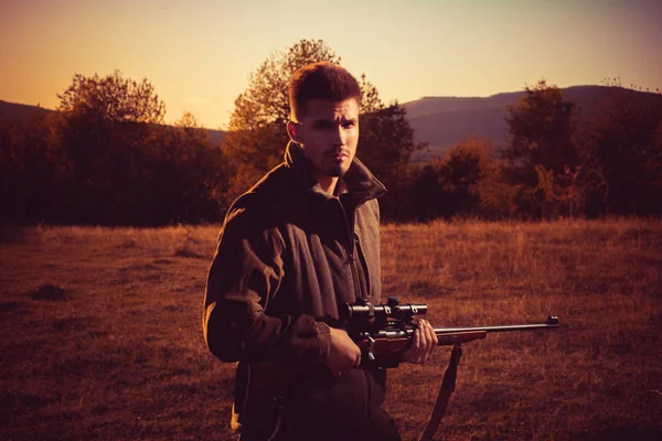 Chasseur avec fusil de chasse en chasse. Chasse illégale braconnier dans la forêt . — Photo