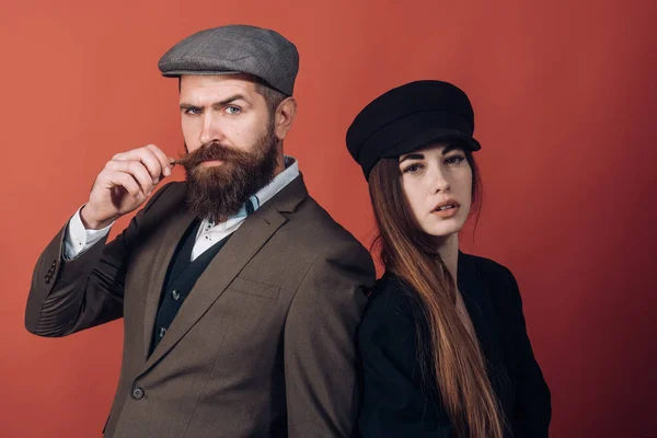 Vintage Retro Paar auf roter Wand. Hut im alten Stil auf bärtigen Mann und schwarze Modemütze auf Schönheit Frau. — Stockfoto
