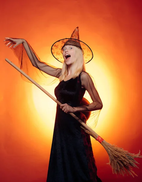 Hermosa joven sorprendida mujer en sombrero de brujas y traje de calabaza celebración. Feliz joven con disfraz de bruja de Halloween en la fiesta sobre un fondo aislado. Cara graciosa. Locos. . — Foto de Stock