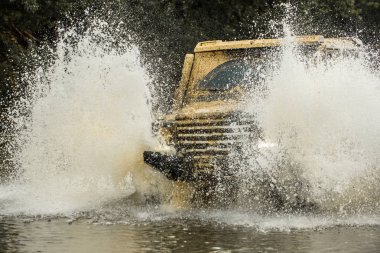 Off-road aracı dağda gider. Lastik yarış için hazırlık. Sefer offroader. Jeep açık havada macera. Mudding off-Road'a benziyor ıslak çamur veya kil yüzölçümü ile.