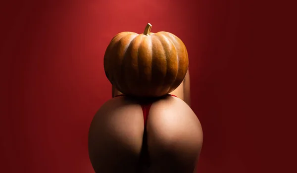 Halloween sexy concept. Big ass for sex celebration. Big ass in intine pose for kamasutra. Hallowen sexy party. Pumpkin on naked big ass. Intime point on woman body. Nightlife and party. — Stockfoto