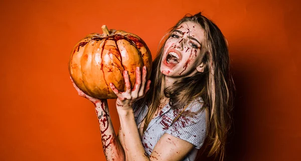 Kobieta z krwawej makijaż. Sexy dziewczyna Halloween w krwi z dyni. Horror zdjęcie sexy dziewczyna morderców przytrzymaj dyni w ręku. — Zdjęcie stockowe