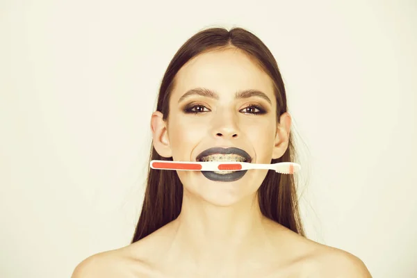 Дівчина з зубними брекетами і пензлем, має модний макіяж — стокове фото