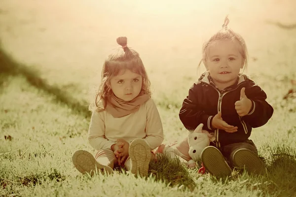 少年は緑の芝生の上の女の子と親指を表示します。 — ストック写真