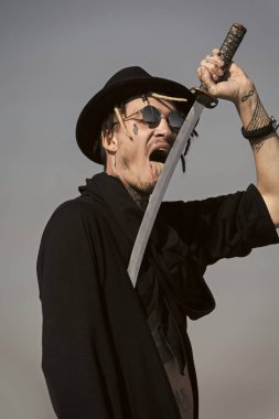 Savaşçı güneş gözlüğü, siyah şapka ve kıyafet