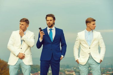 Cep telefonu mavi gökyüzü üzerinde tutan adam