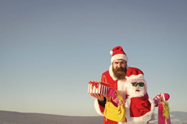 Mutlu Noel Baba hipster mevcut kutu mavi gökyüzü üzerinde tutan