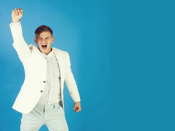 Businessman celebrating achievement on blue background