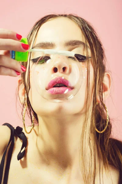 Chica con soplador de burbujas sobre fondo de estudio rosa — Foto de Stock