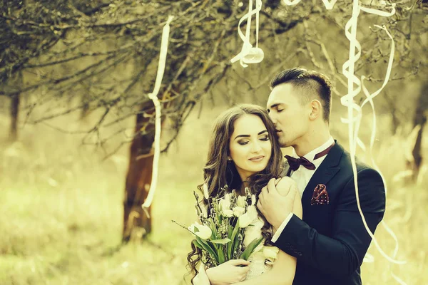 幸せな新婚カップルのポーズし笑顔の結婚式でドレスし 屋外のリボンで飾られた森林の花と合わせて — ストック写真