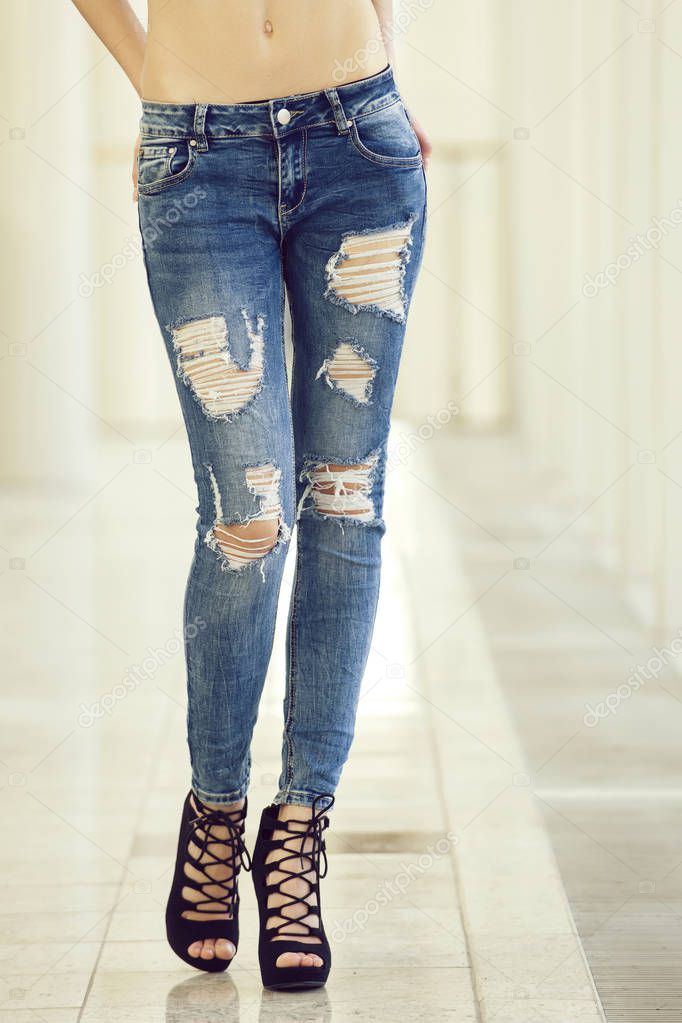 girl in jeans on legs of young woman in fashionable shoes