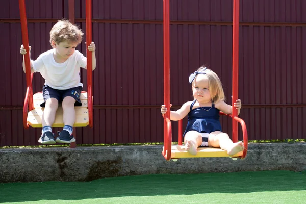Där vi växer upp. Små barn med blont hår på swing. Lilla bror och syster leka tillsammans. Flicka och pojke frisyr styles. Frisörsalong för barn. Något nytt och annorlunda — Stockfoto