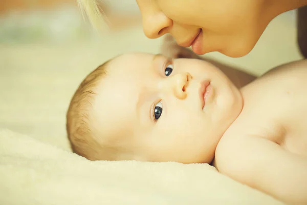 Mother kissing her son newborn