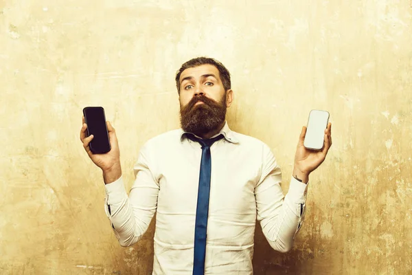 Man of hipster vergelijk GSM en smartphone — Stockfoto