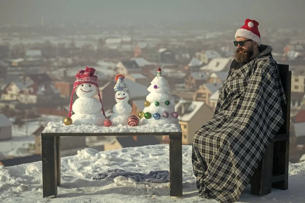 Man in geruite deken zit op stoel op de winterdag — Stockfoto