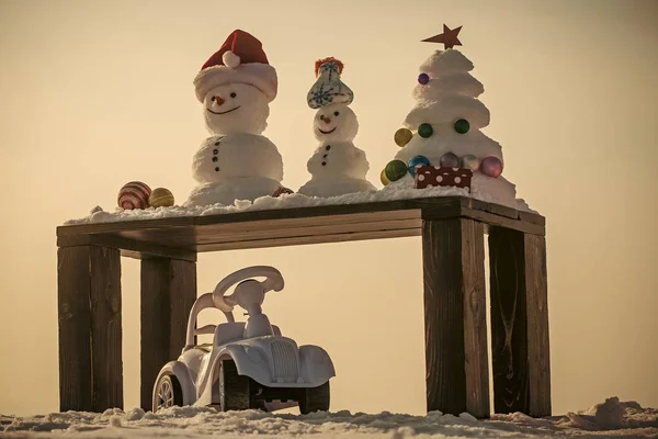 Sneeuw sculpturen op houten tafel op witte hemel — Stockfoto