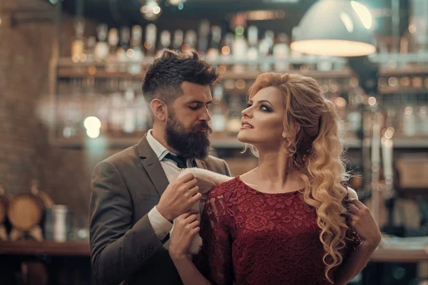 Una joven pareja hipster en un café. Él le pone un pelaje en los hombros, ella está mirando. Conceptos de amor o amistad . — Foto de Stock