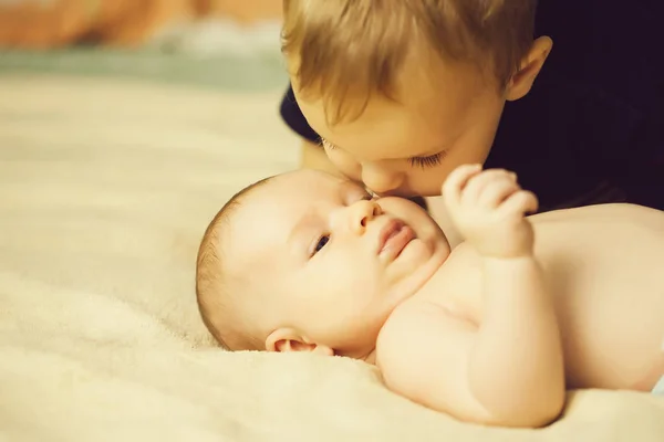 Мальчик целует своего маленького брата — стоковое фото