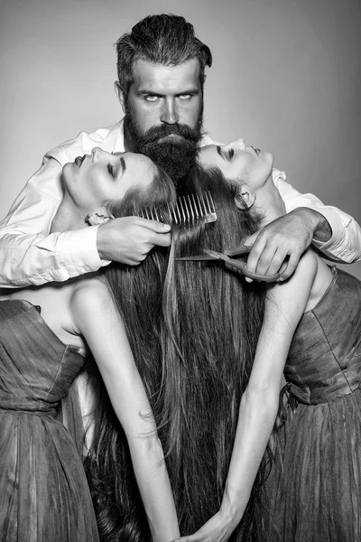 Бородатый мужчина парикмахер и две женщины — стоковое фото