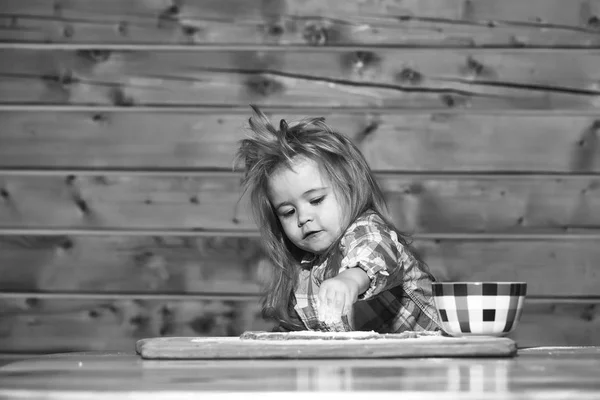 Słodkie dziecko gotowanie z ciasta, mąki i miski na drewno — Zdjęcie stockowe