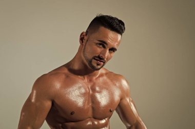 Atletik vücut geliştirmeci adam gri arka plan üzerinde.