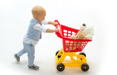 little boy go shopping with full cart. little boy child in toy shop. shopping for children. happy childhood and care. savings on purchases. Excitement. Friendly shop assistant. Needful purchase clipart