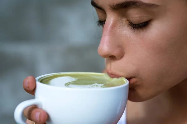 matcha latte tea ceremony of girl. Getting warm with hot tea. perfect morning with green coffee. woman drink japanese tea from cup. woman relax in cafe and drinking. Her perfect breakfast