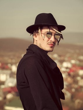 Erkek Güneş gözlüğü, siyah şapka ve kıyafet açık havada poz