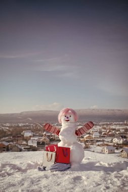 Pembe peruk ve mittens hediye paketi ile kardan adam.