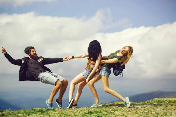 Duas meninas bonitas puxar o homem — Fotografia de Stock