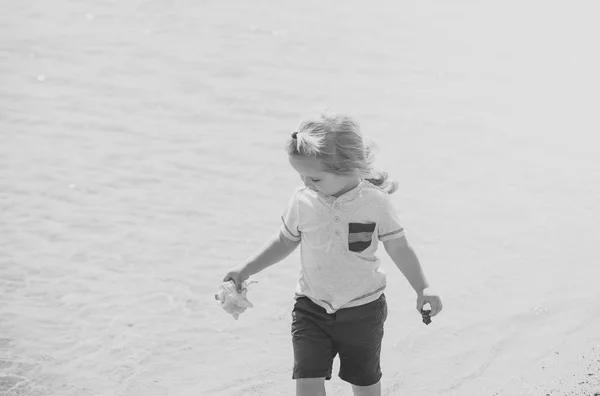 Niño con concha en la playa de mar — Foto de Stock