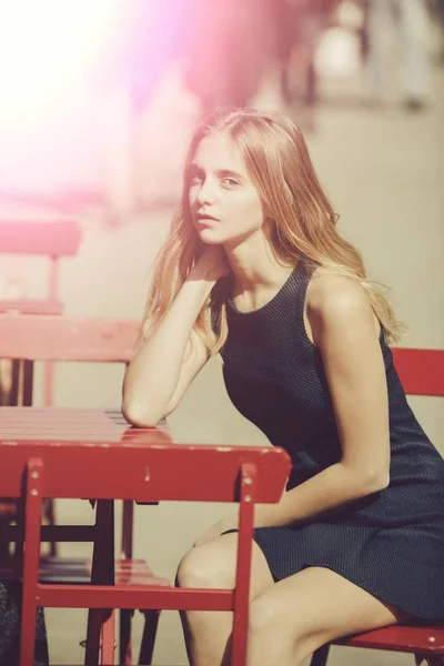 Chica bonita esperando el orden en la cafetería de la calle a la luz del sol —  Fotos de Stock