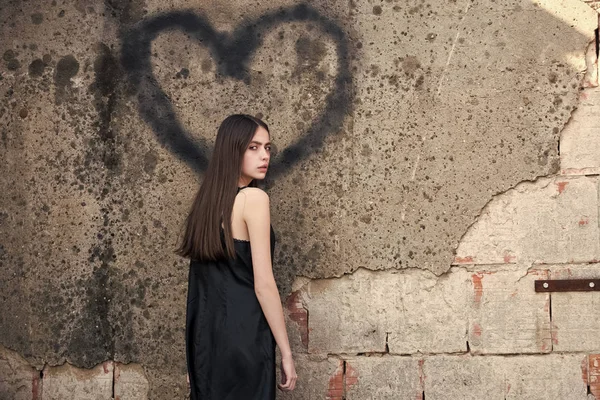 Vrouw poseren met hart graffiti op muur grijs — Stockfoto