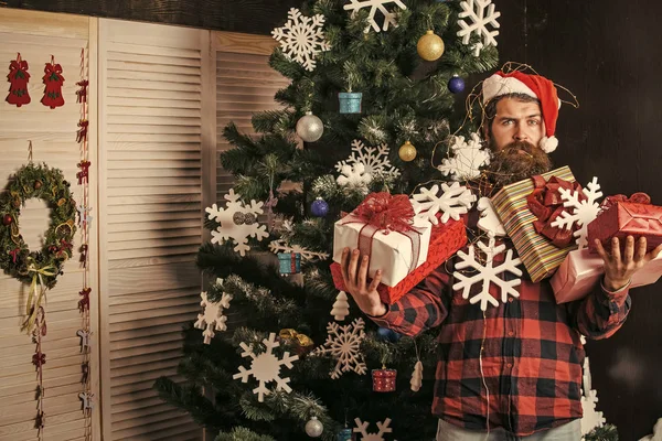 Χριστούγεννα άνδρας με γενειάδα στο πρόσωπό κρατήστε πατημένο το δώρο. — Φωτογραφία Αρχείου